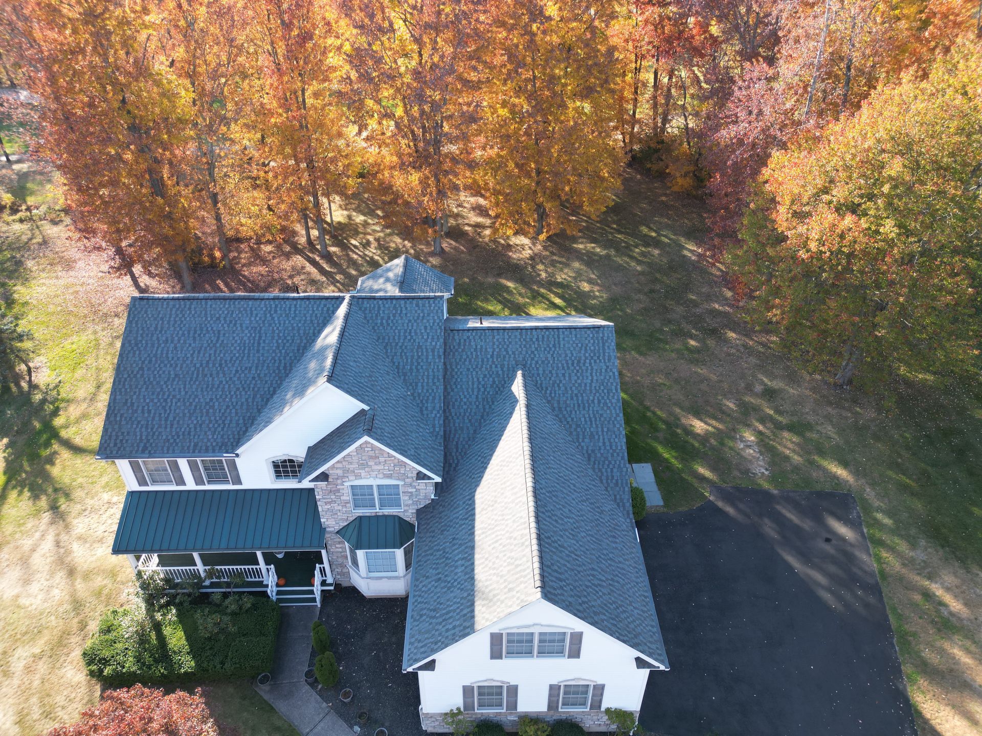 An aerial view of a house with trees in the background