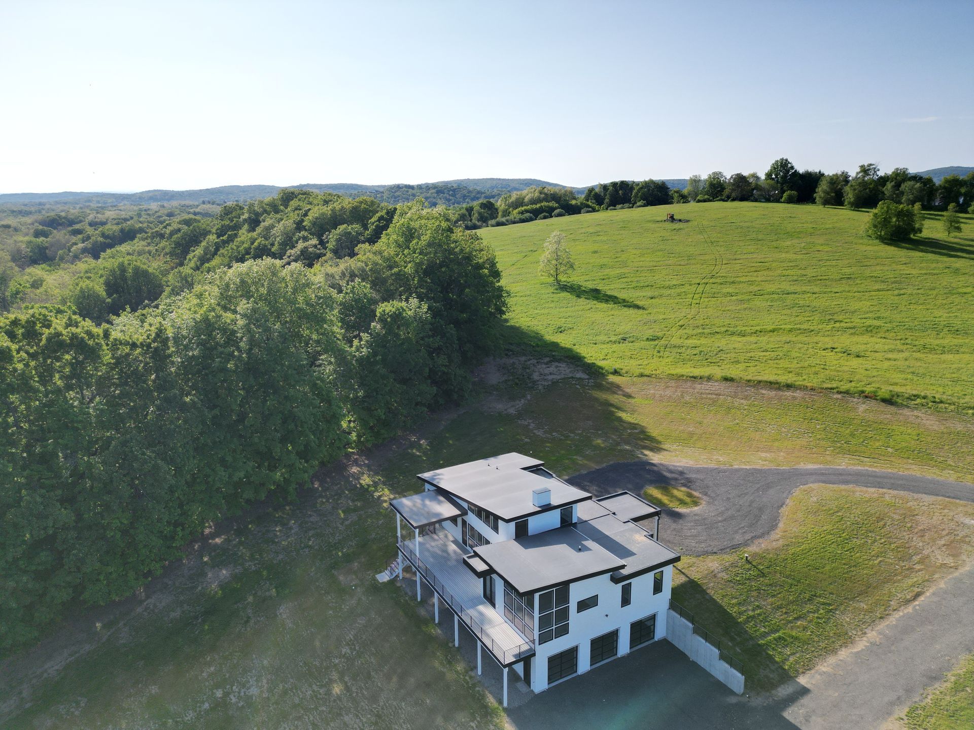 An aerial view of white home with flat and low-sloped roof replacement 