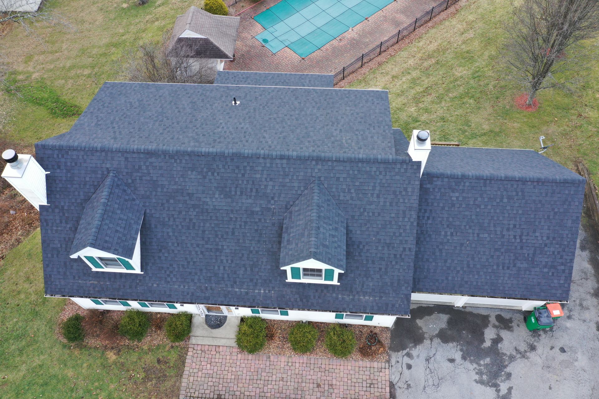 Dark roof replacement on white home top, front view