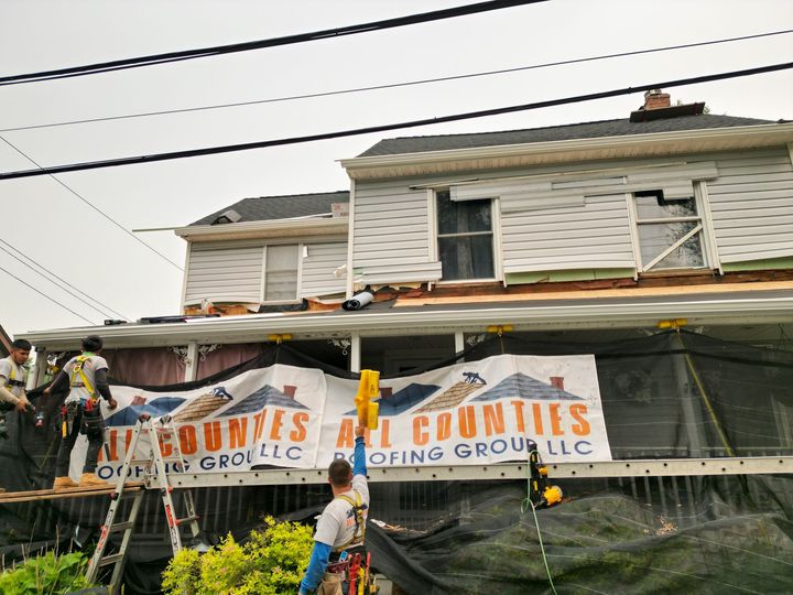 Roof replacement in progress with All Counties Roofing Banner logo