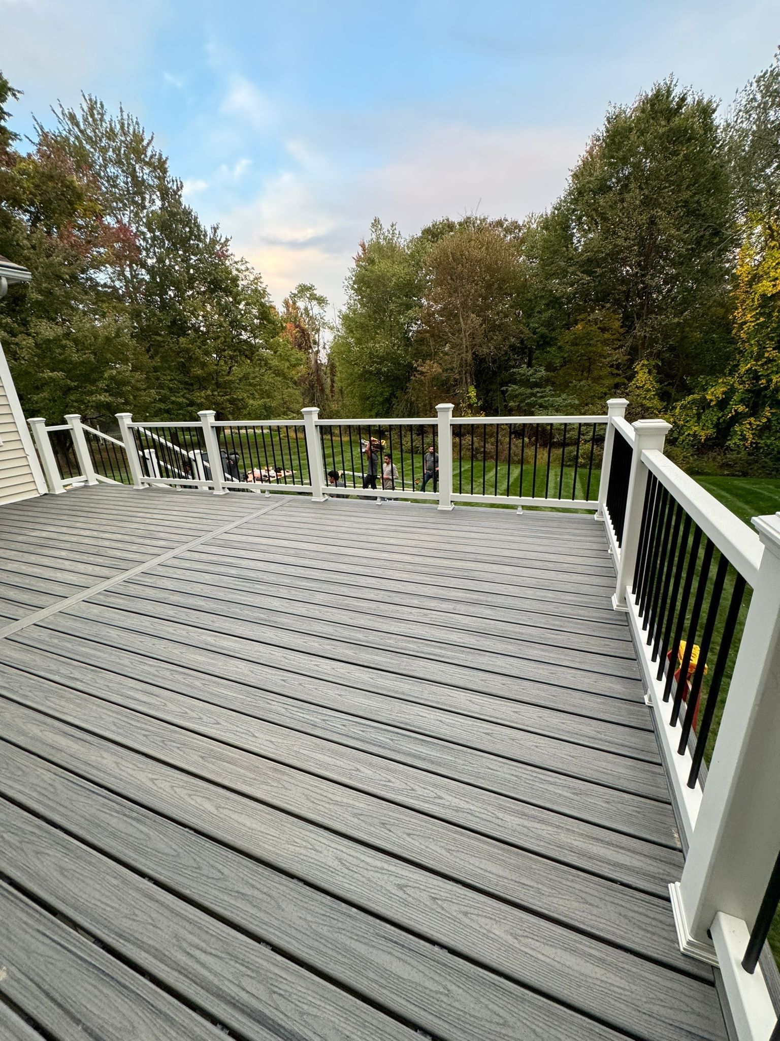 A large gray deck with a white railing build