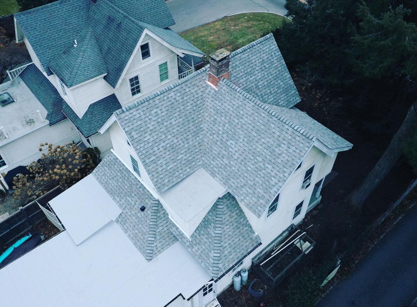 Roof replacement on white home with gray roof-top view