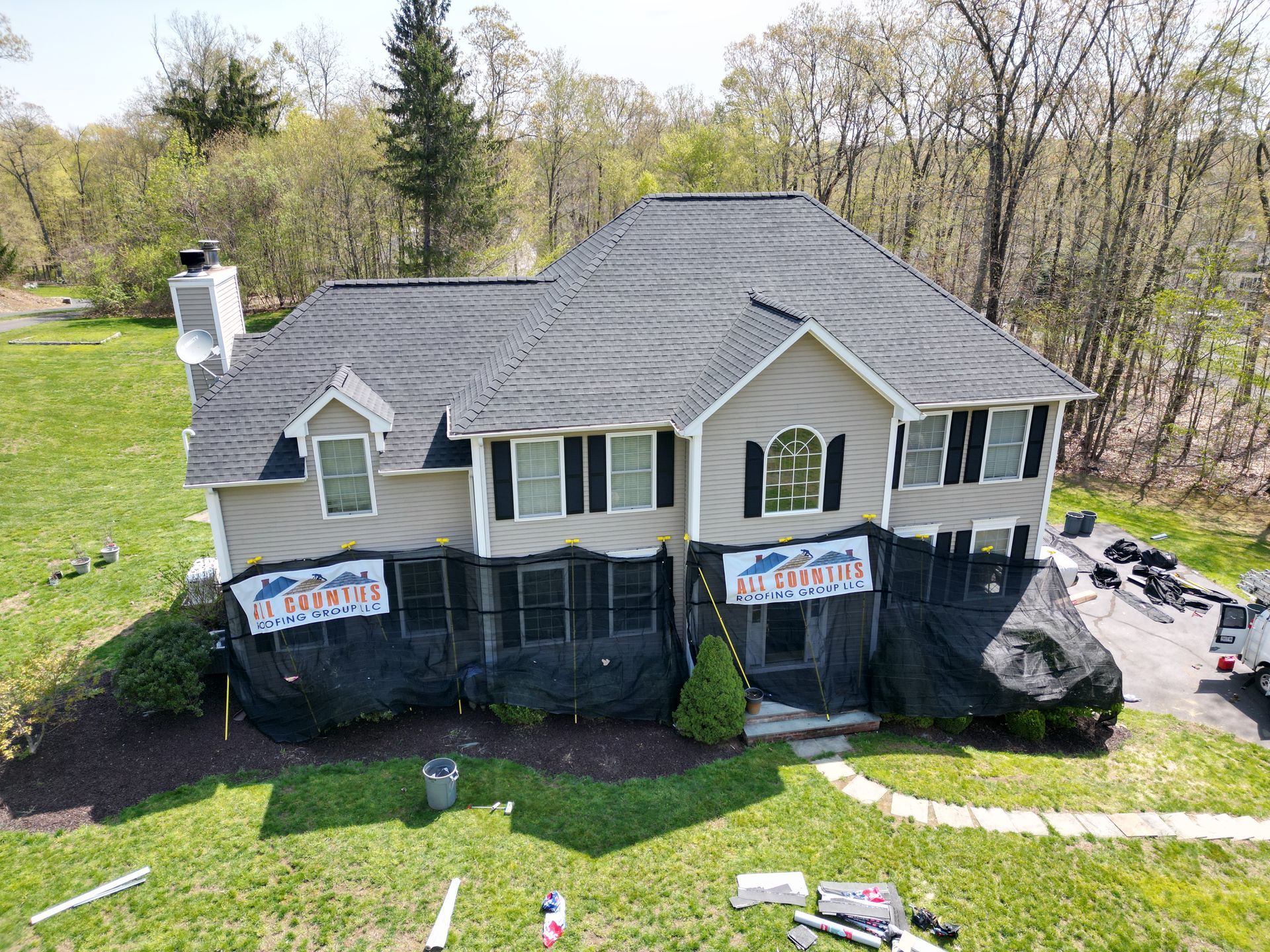 An aerial view of a house with a new roof being installed.