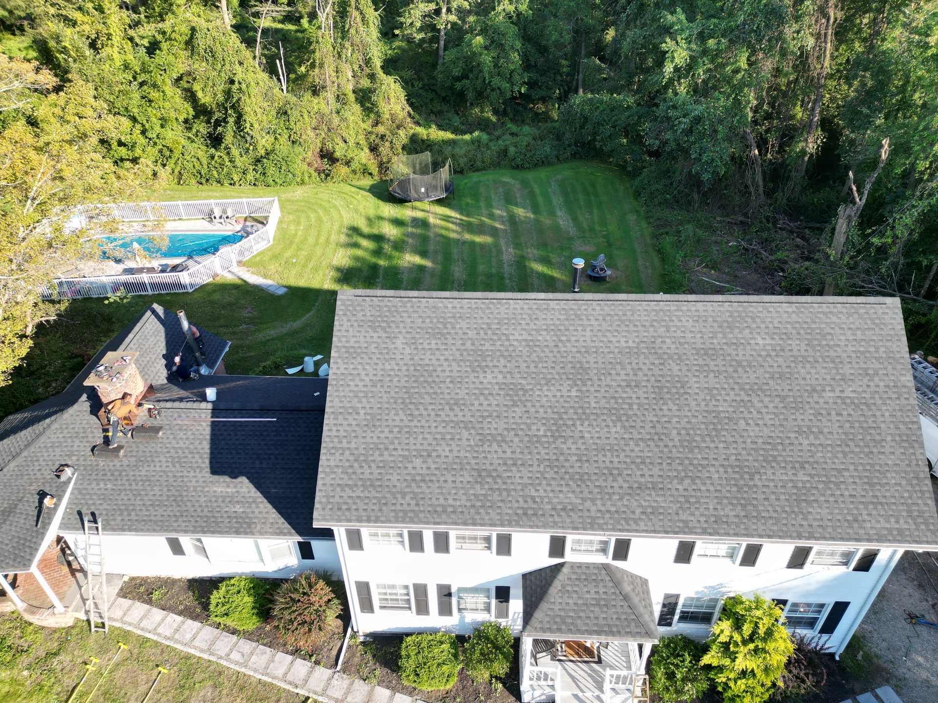 An aerial view of a house with a pool in the backyard