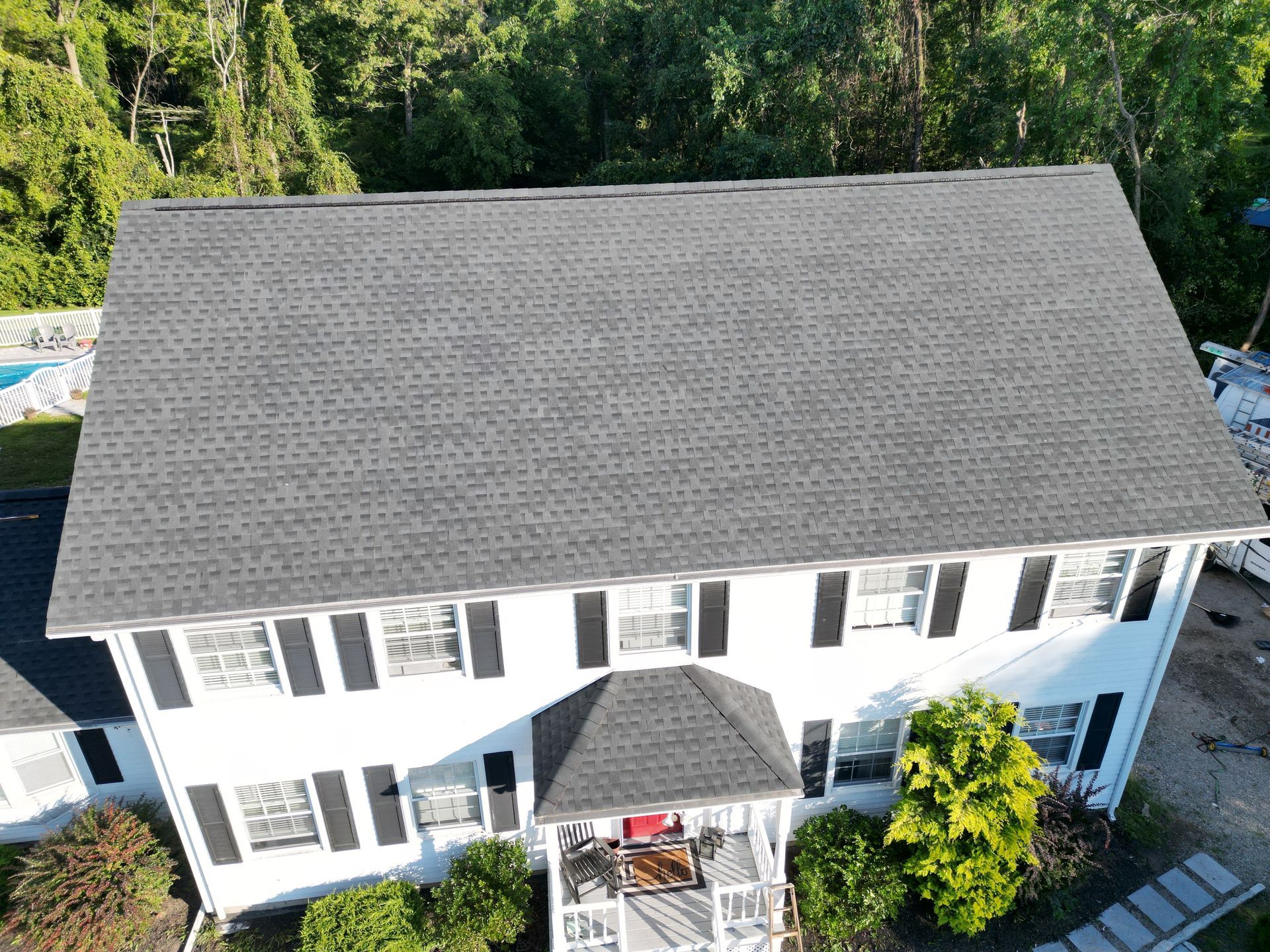 An aerial view of a white house with a black roof installation