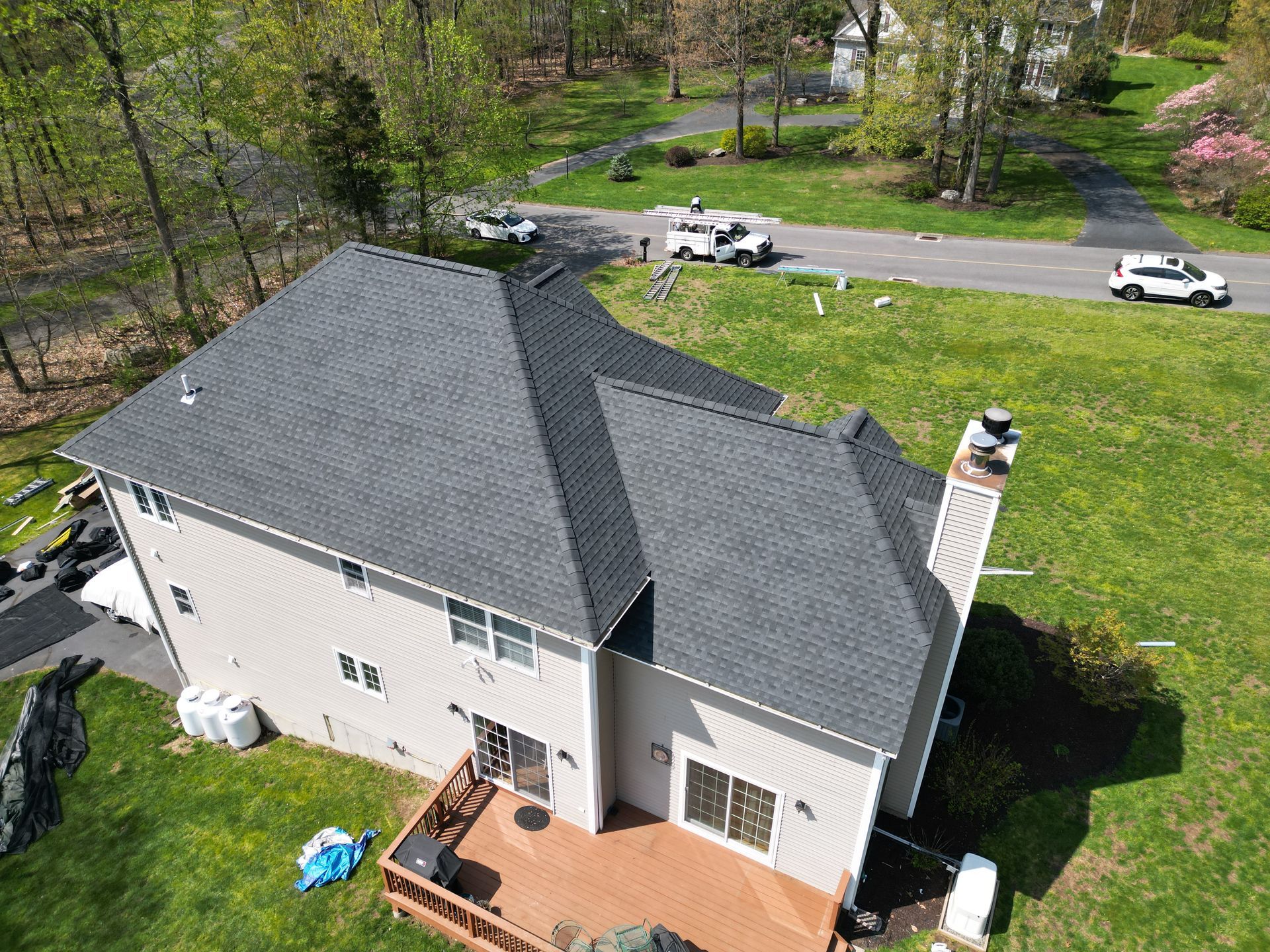 An aerial view of a house with a new roof and a deck.