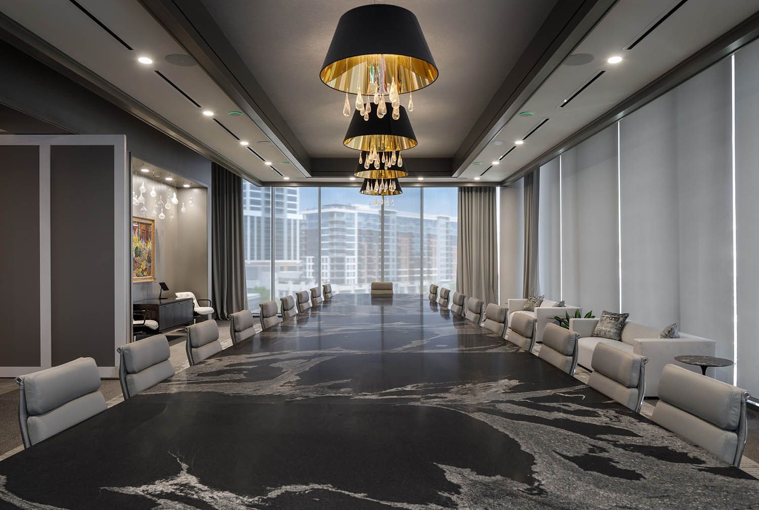 A large room with a long table and chairs and a chandelier hanging from the ceiling.