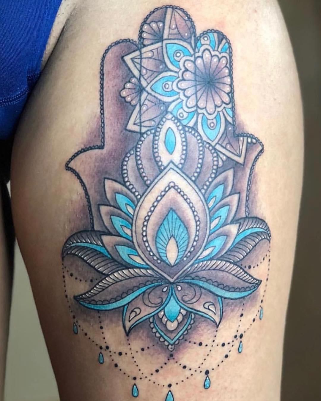 Hamsa hand tattoo on thigh, featuring a lotus flower and mandala in blue and gray.