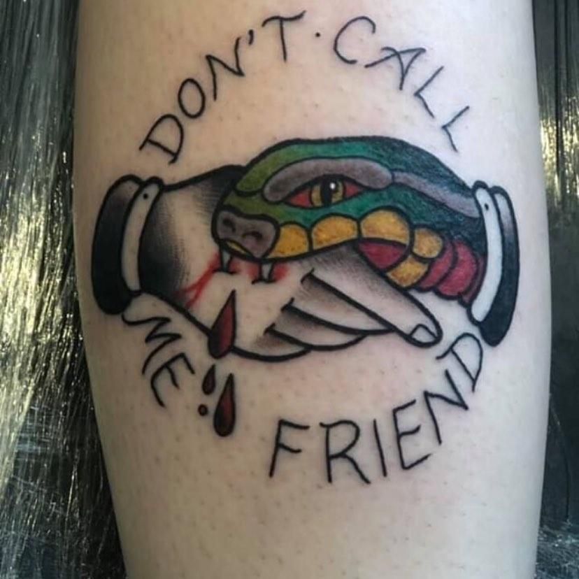 Tattoo of a snake biting a hand with the words 