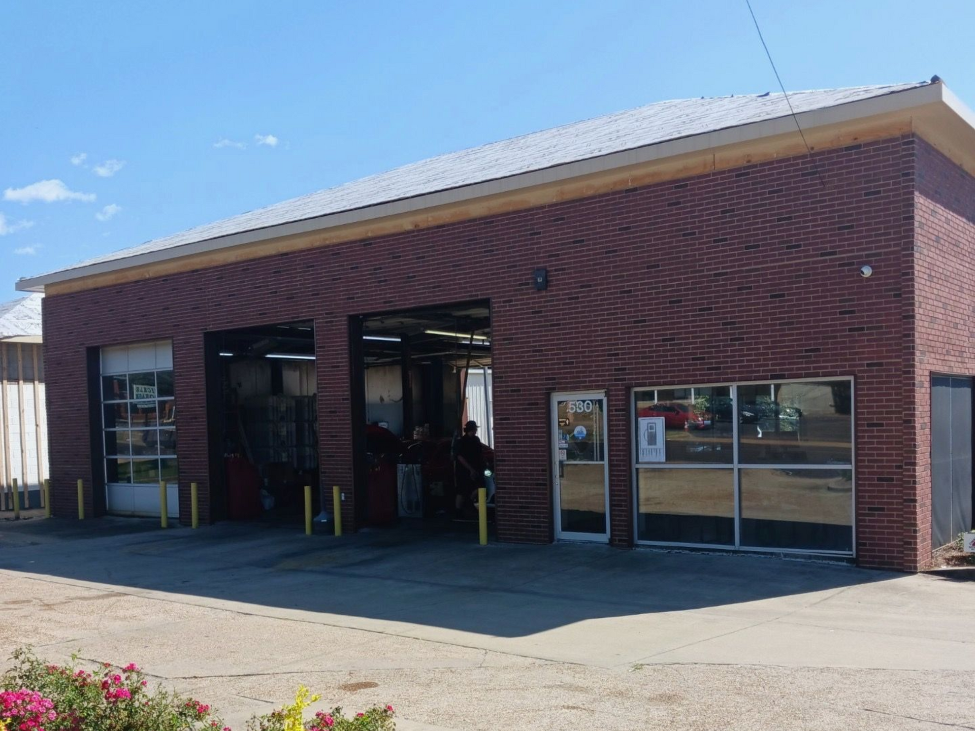 A Shell Rapid Lube gas station on a sunny day, with a clear blue sky and green landscaping.