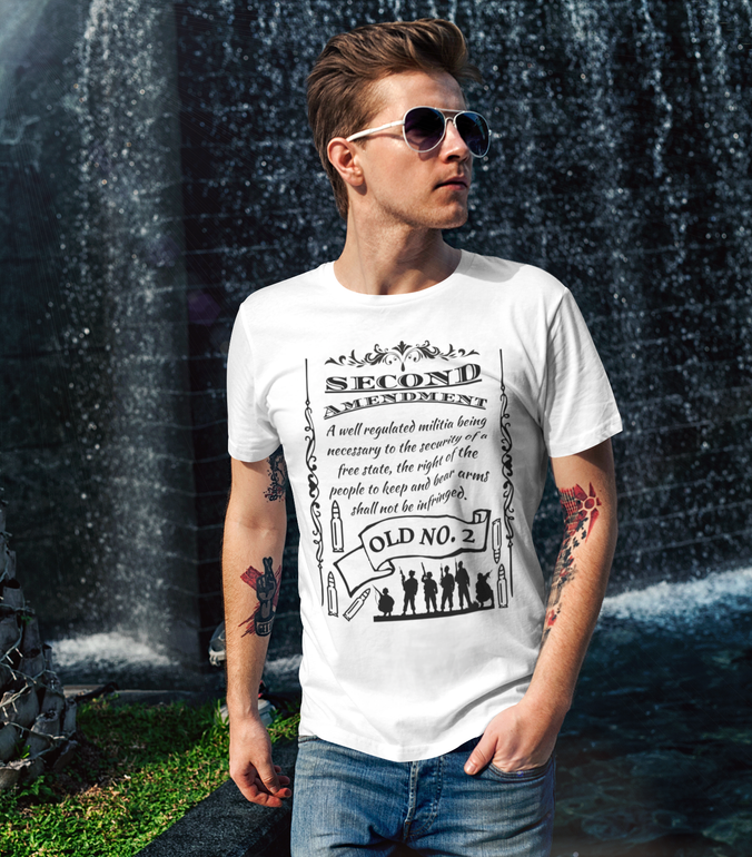 A man wearing sunglasses and a white t-shirt stands in front of a waterfall