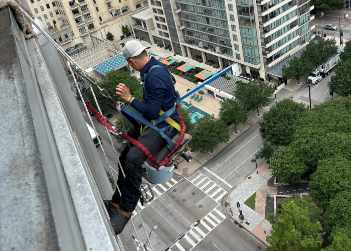 A man is sitting on the side of a building.