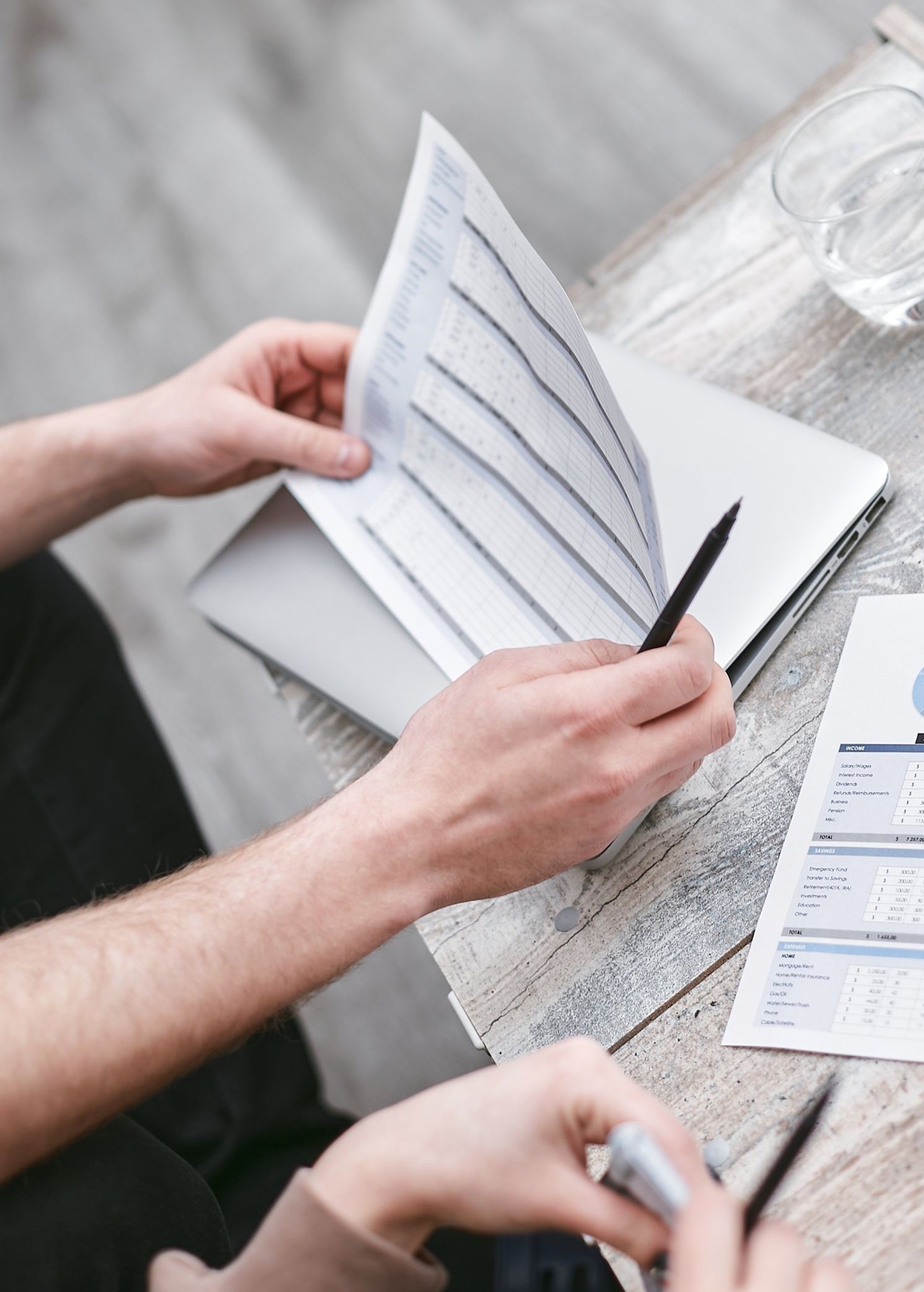 A man and a woman are sitting at a table looking at papers.