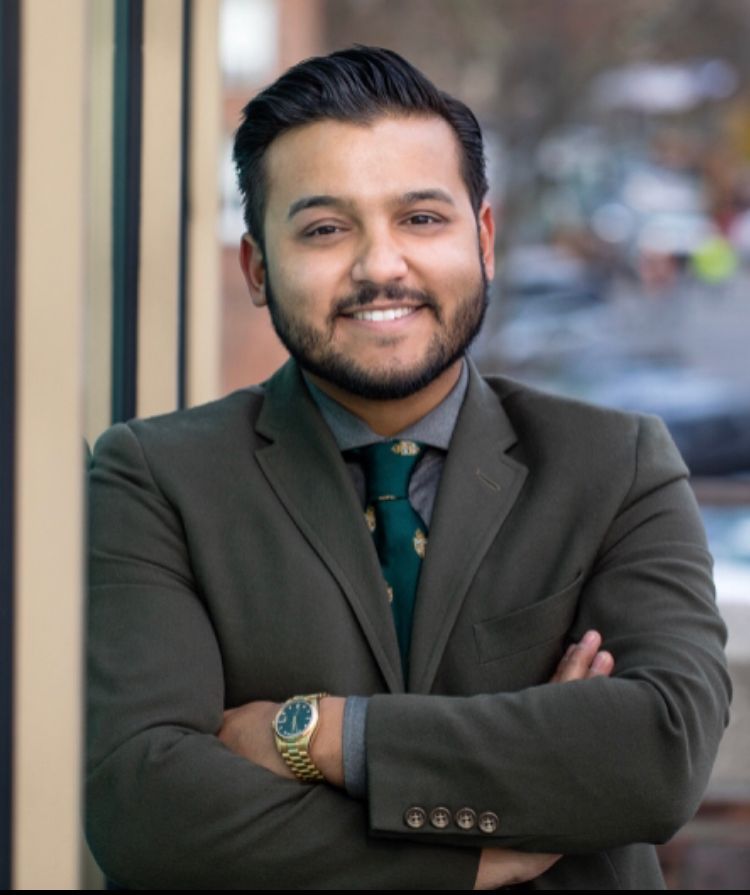 A man in a suit and tie with his arms crossed