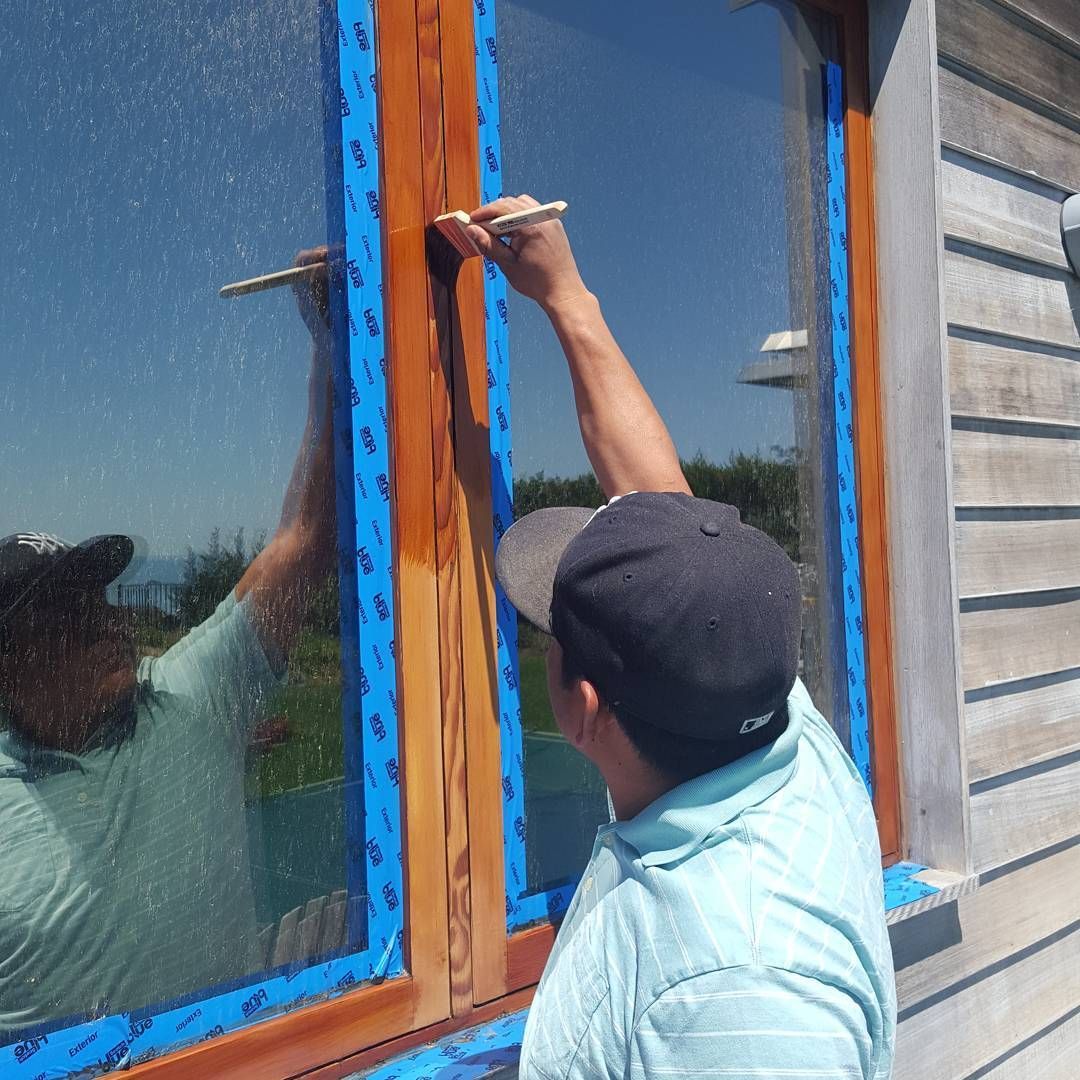 A man is painting a window with a brush
