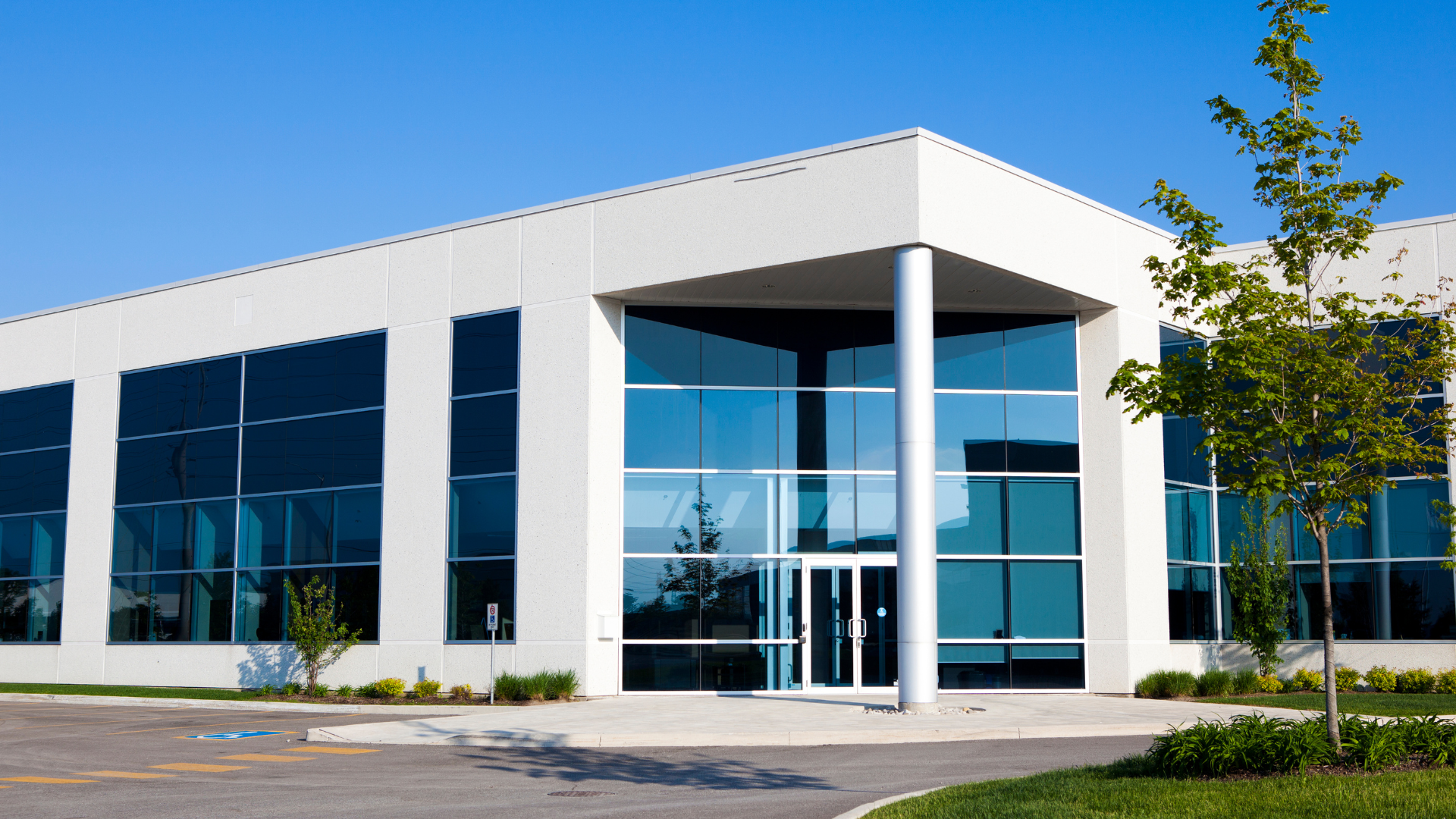 A brick building with a blue roof and a lot of windows.
