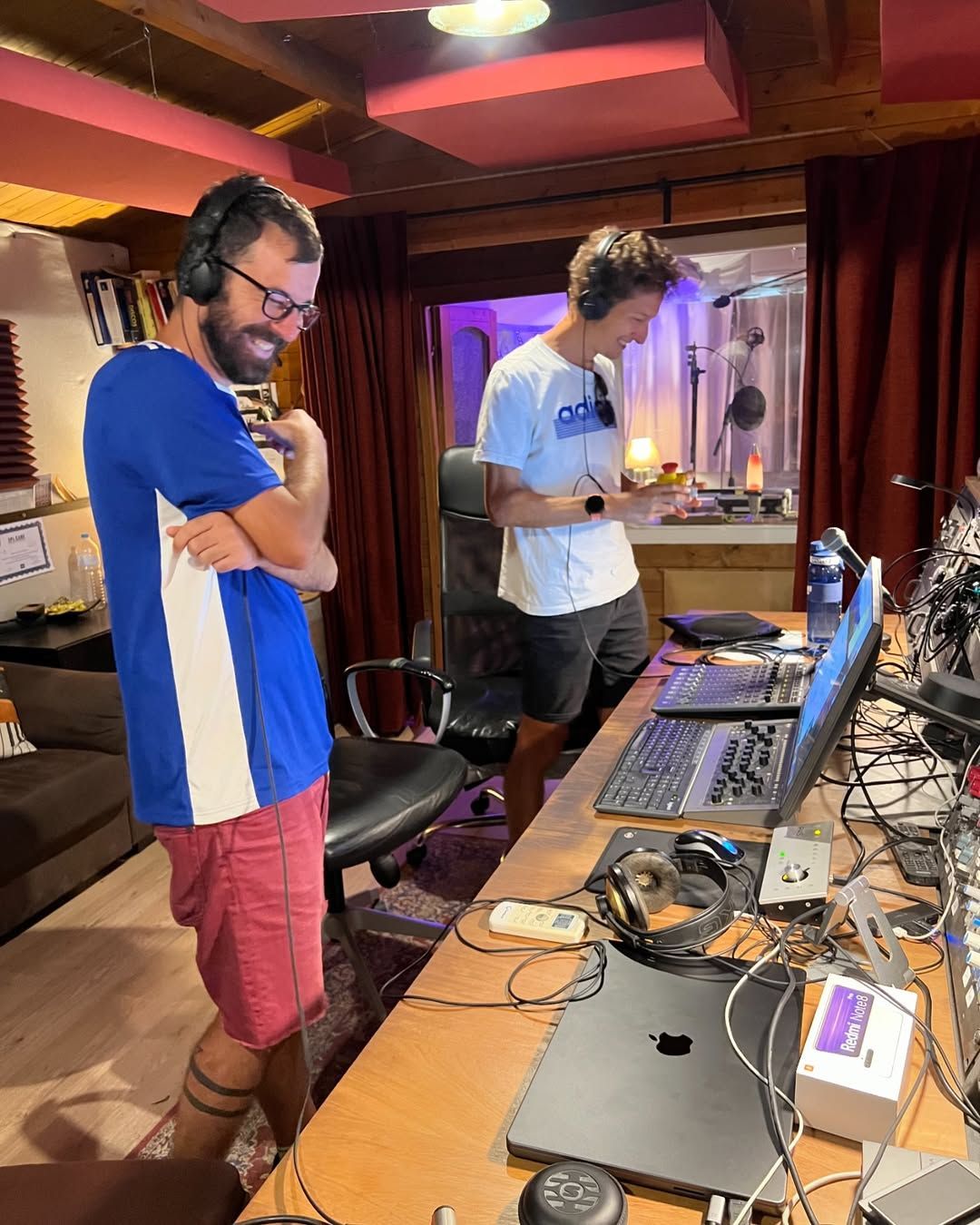 Dos hombres están parados uno al lado del otro frente a una computadora portátil.