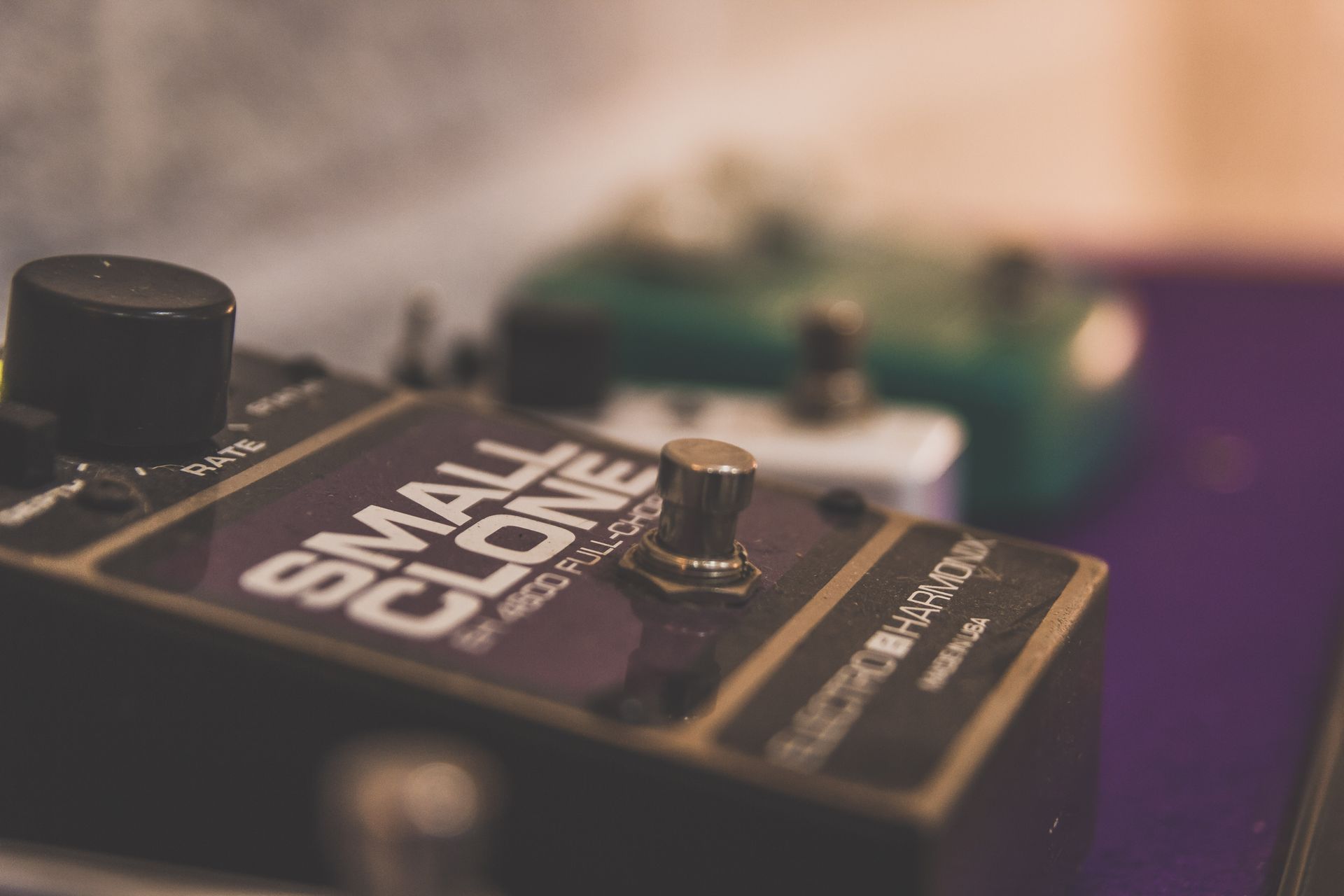 Un primer plano de un pequeño pedal de guitarra clon sobre una mesa.