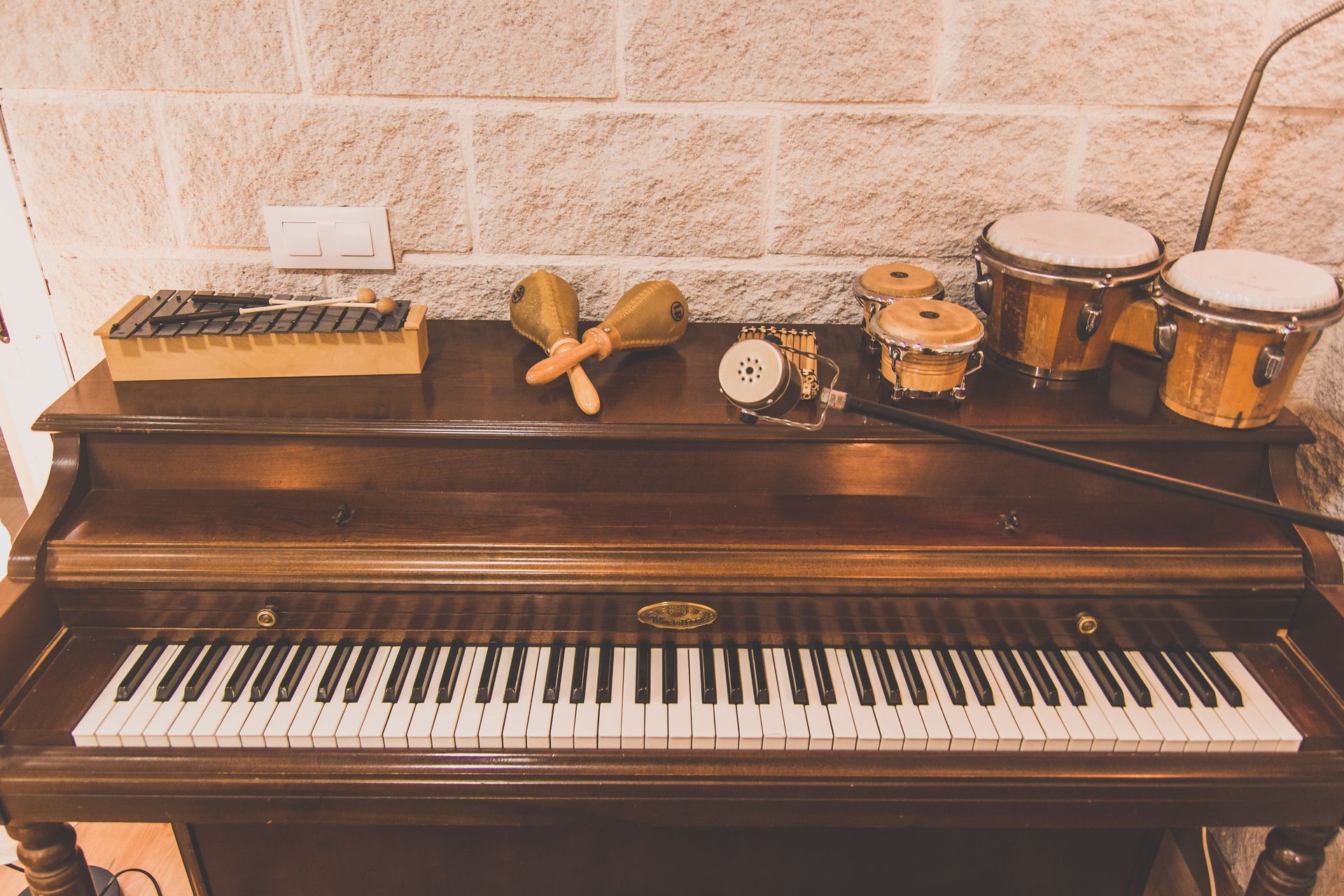 Un piano con un montón de instrumentos musicales encima.