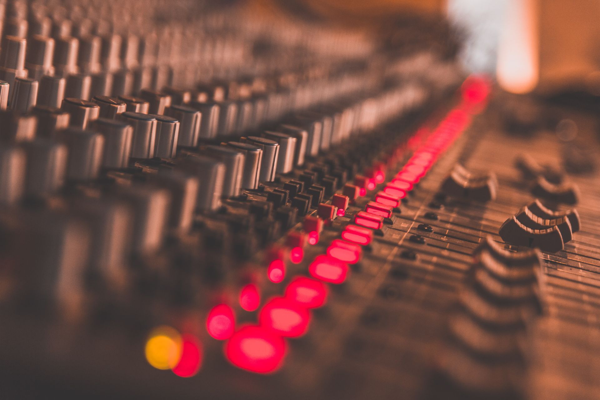 Un primer plano de un mezclador de sonido con luces rojas.