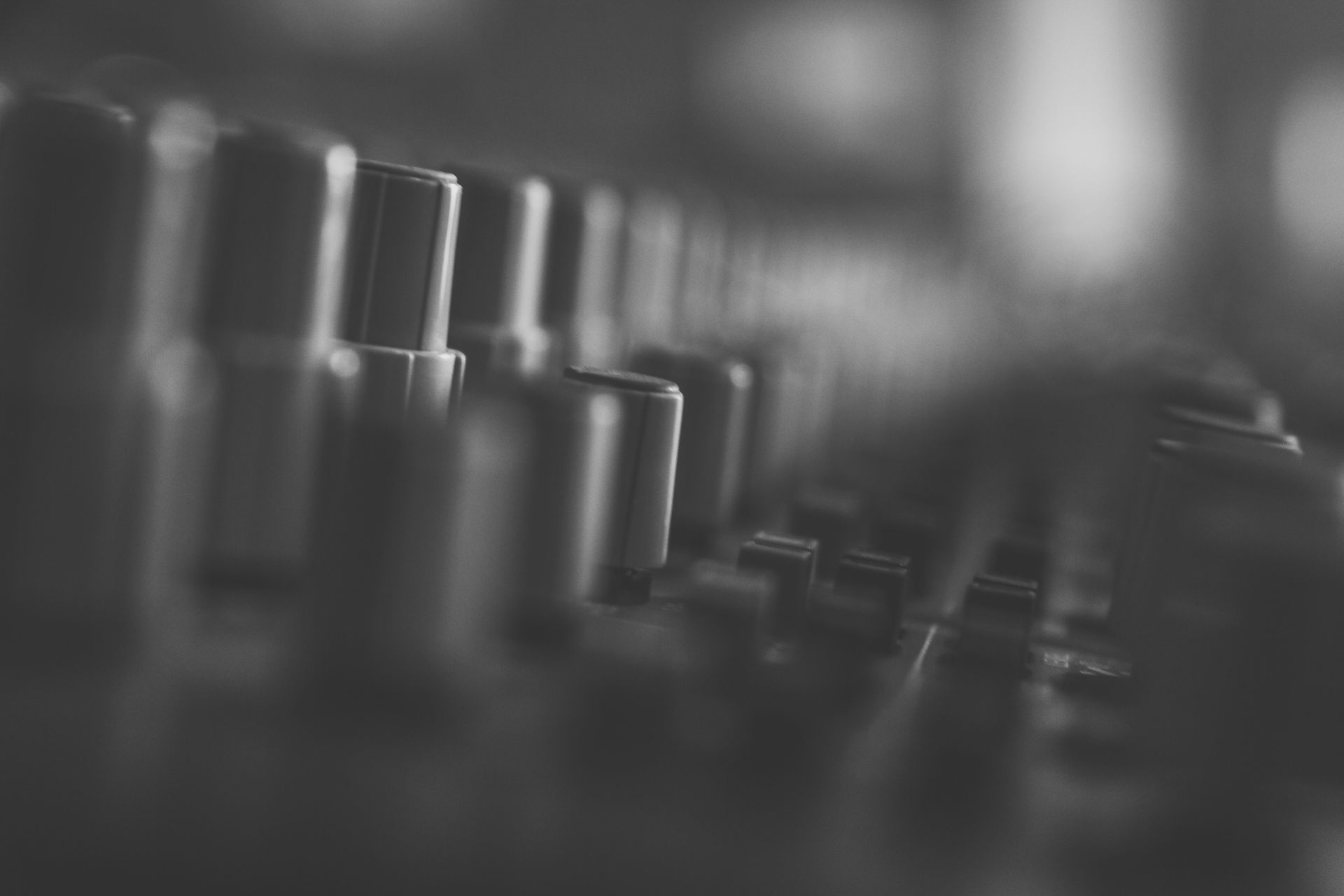 Una fotografía en blanco y negro de una fila de perillas en un mezclador.