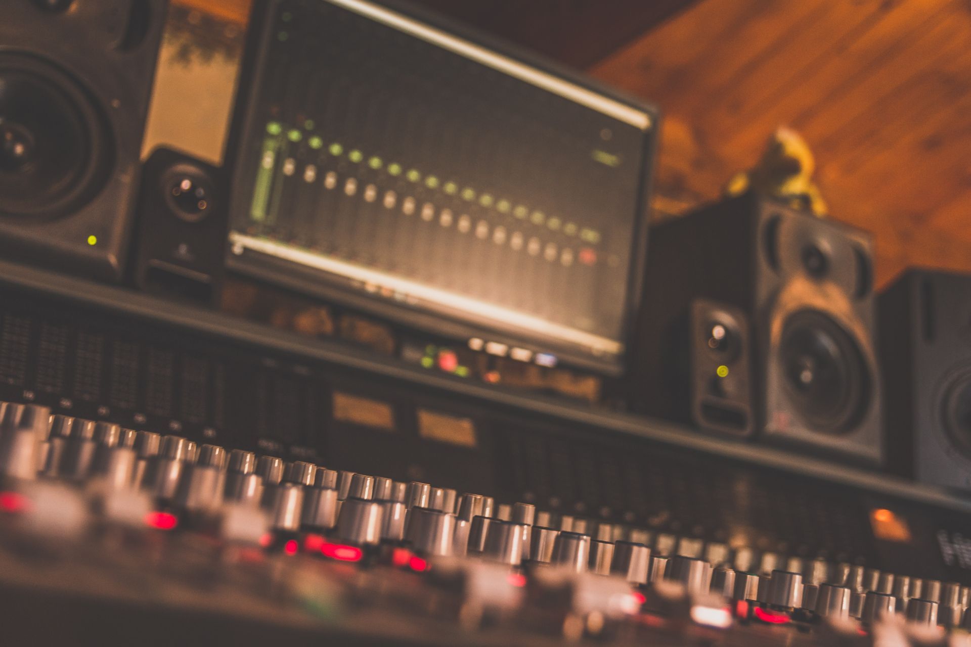 Un estudio de grabación con una computadora, parlantes y un mezclador.