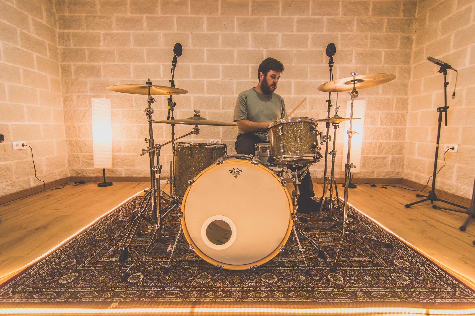 Un hombre está tocando la batería en un estudio de grabación.