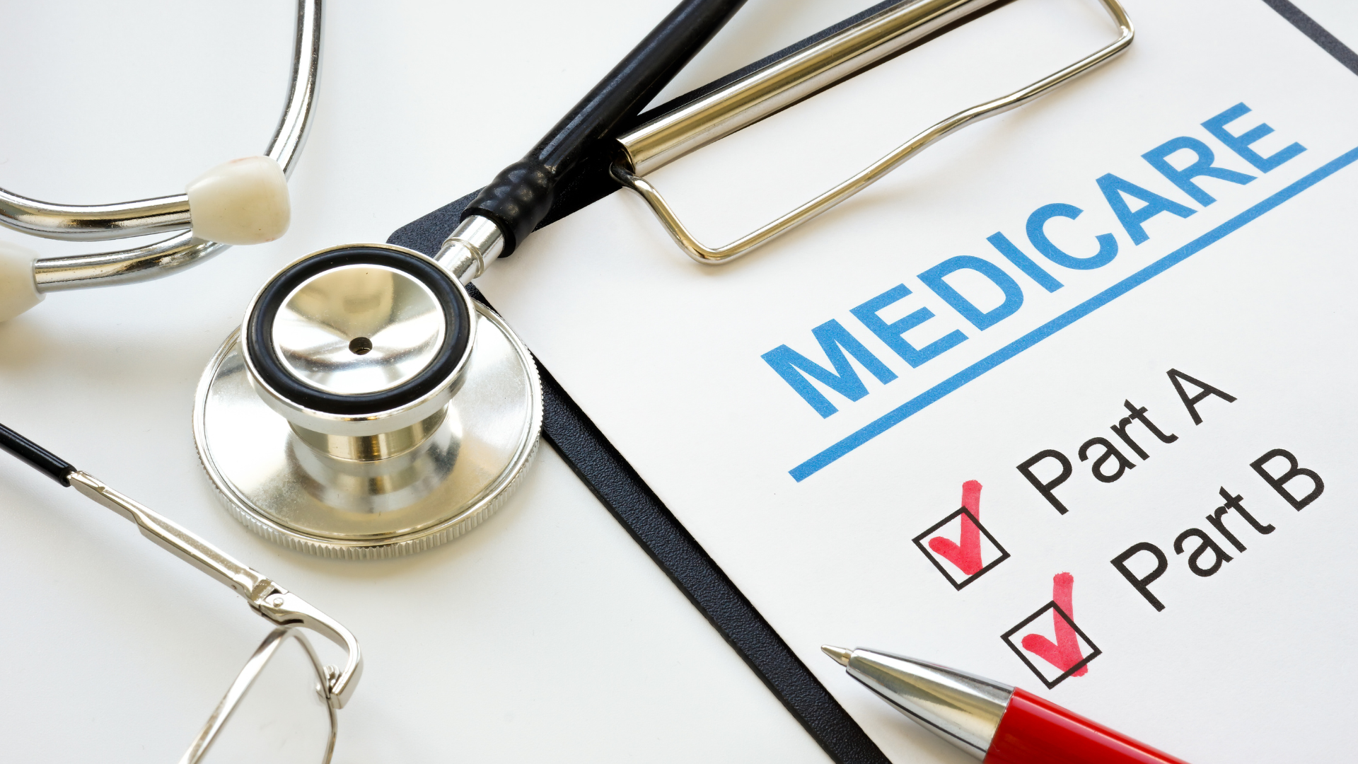A stethoscope is sitting on top of a clipboard with the word medicare written on it.