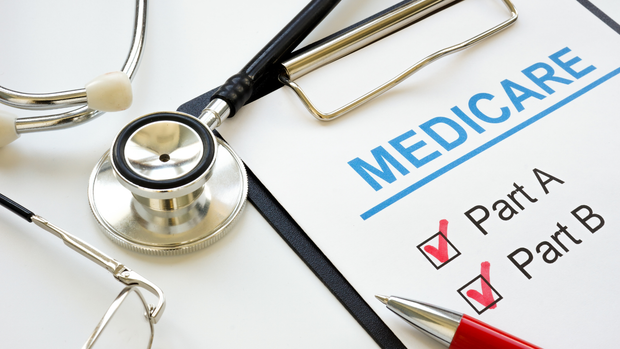 A stethoscope is sitting on top of a clipboard with the word medicare written on it.