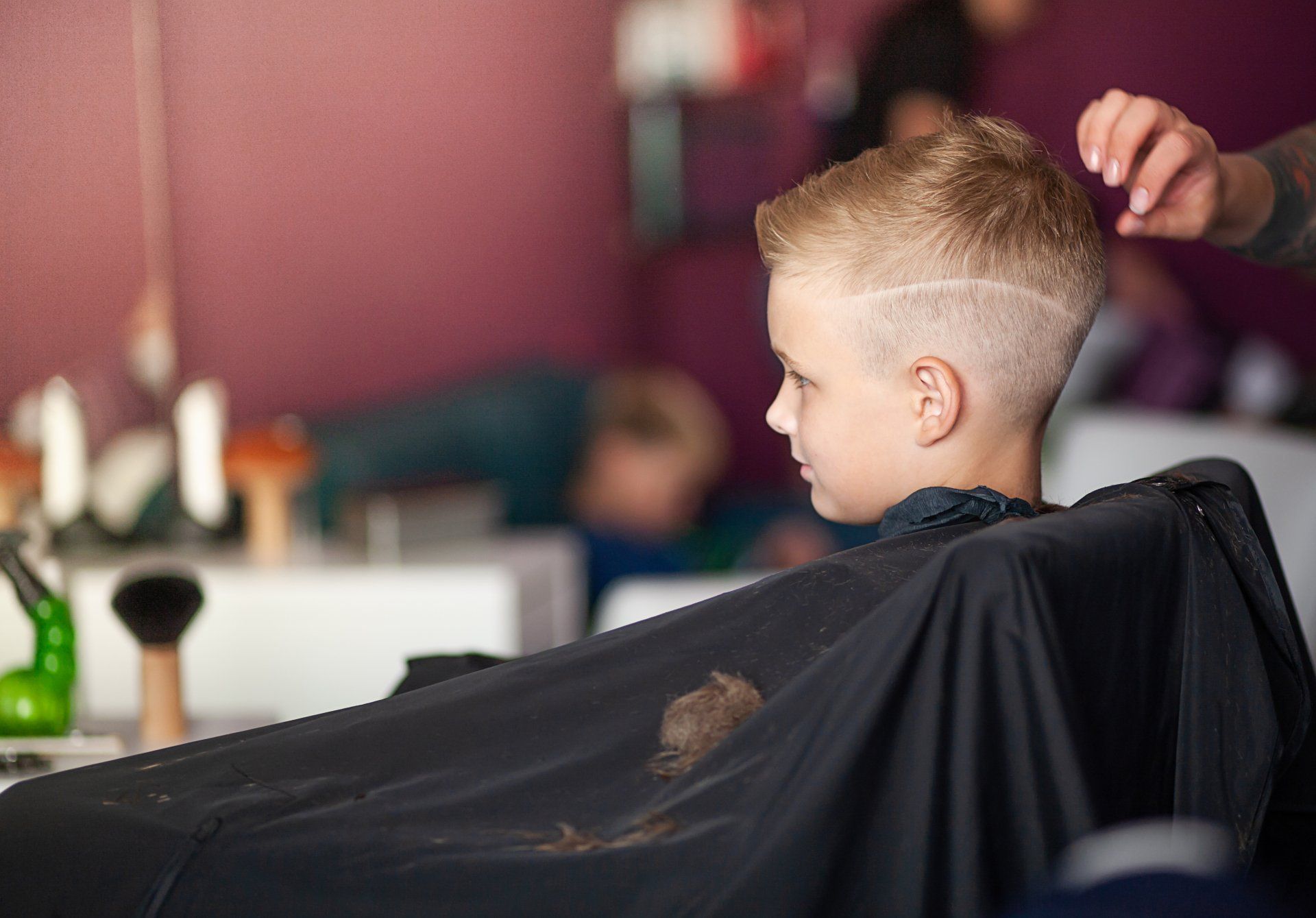 a schoolchild is getting hair cut in a beauty salon