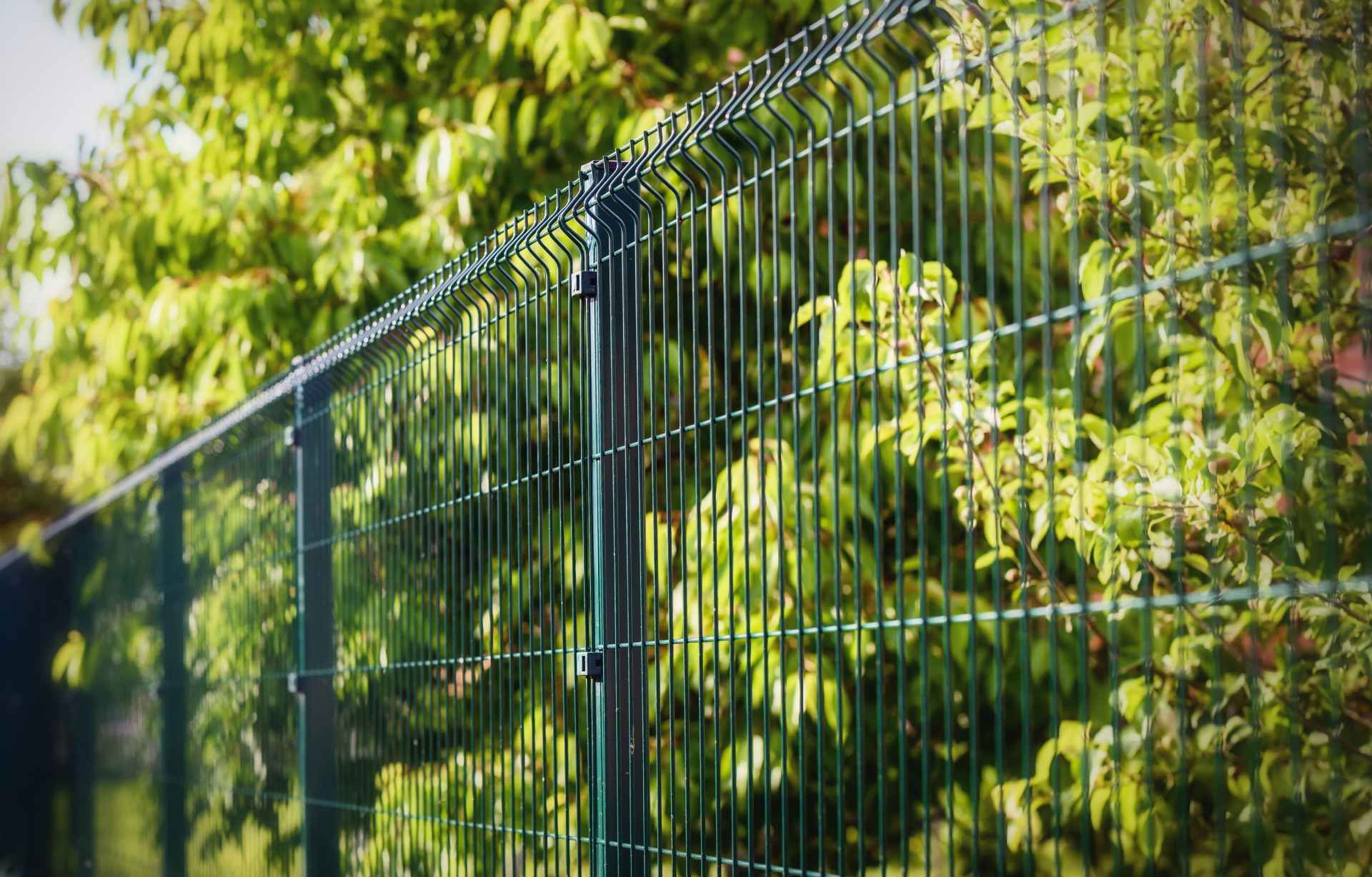 close up of a fence with trees in the background.