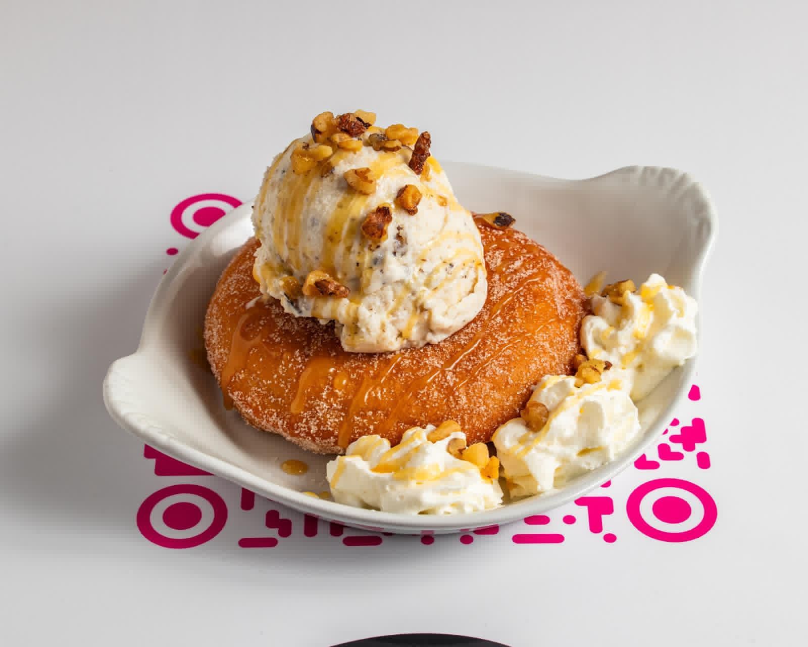 Crêpe avec glace et sauce au chocolat sur assiette bleue, décor extérieur.