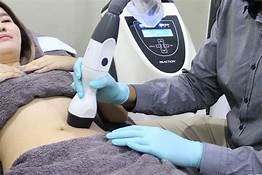 woman undergoing body sculpting procedure on her abdomen using Viora V-Form device