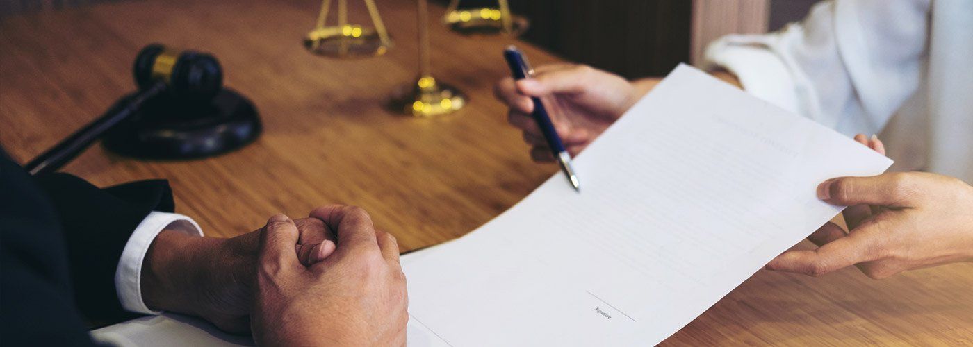 Image Show On Pickering Law Corporation Website Of Hands Crossed At A Table Reviewing A Legal Contract