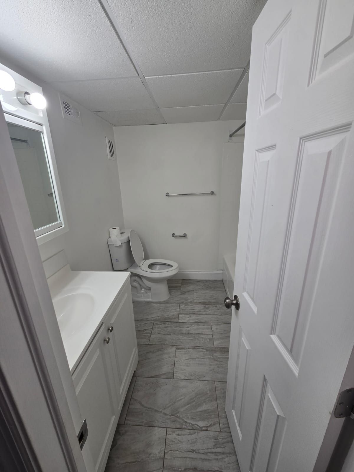 Bathroom with toilet and simple white tile interior at Chateau Apartments Burlington, NJ