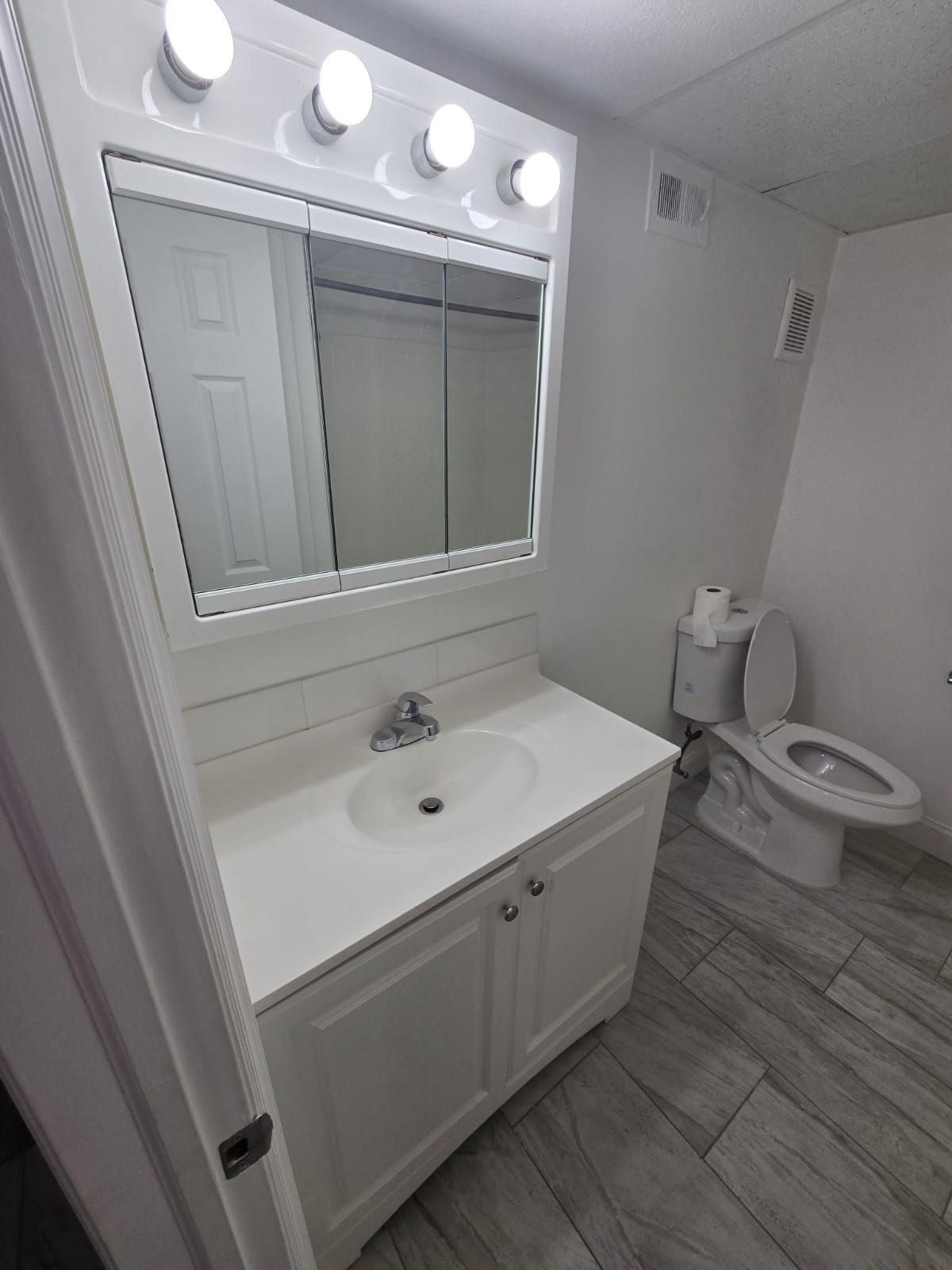 Bathroom vanity with mirror and bright lighting at Chateau Apartments Burlington, NJ