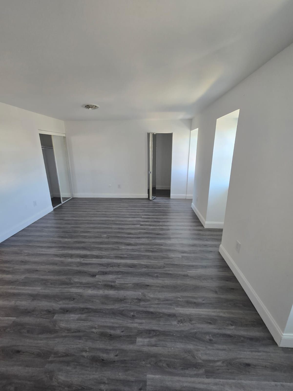 Spacious bedroom with large windows and light walls at Chateau Apartments Burlington, NJ