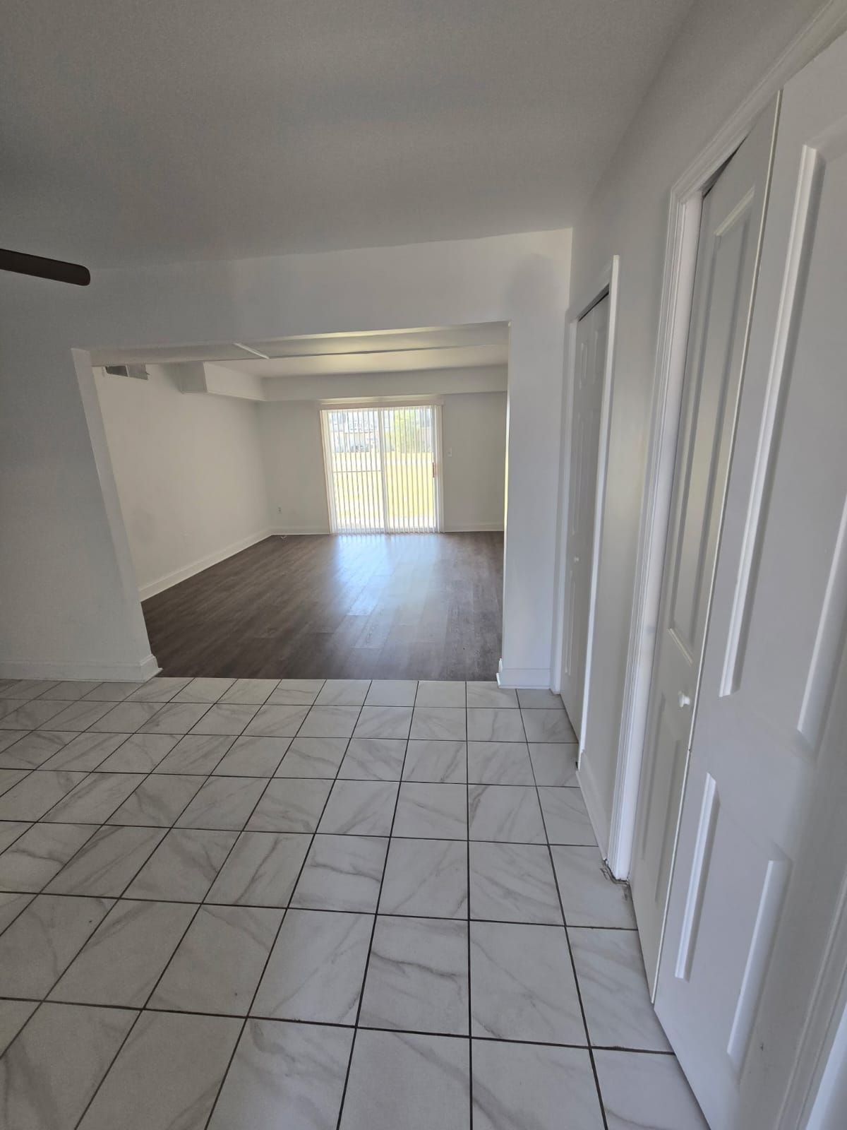 Dining and living room space with patio doors and bright daylight at Chateau Apartments Burlington, NJ