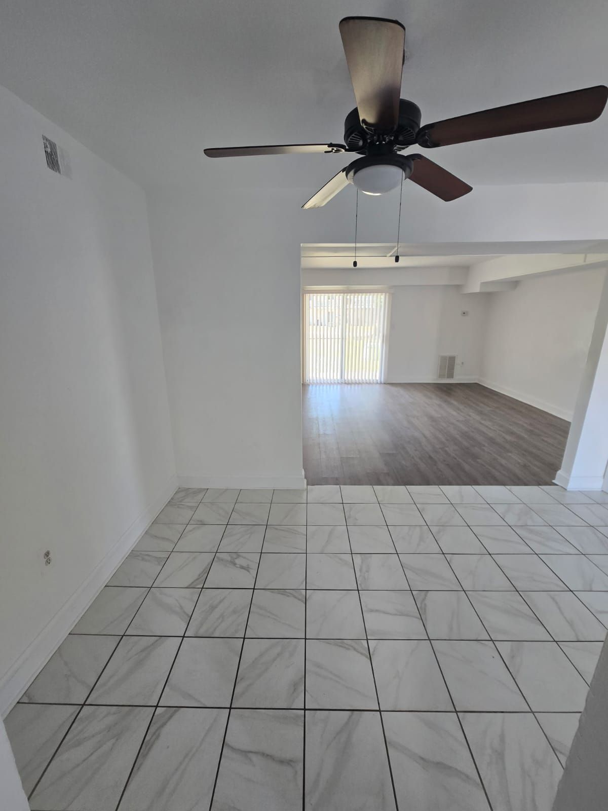 Dining and living area featuring ceiling fan and large windows at Chateau Apartments Burlington, NJ