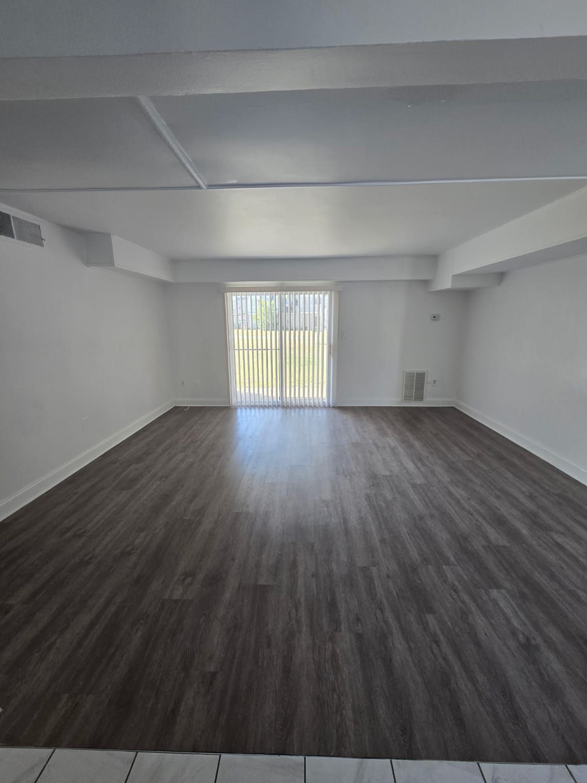 Living room with patio door and natural light at Chateau Apartments Burlington, NJ
