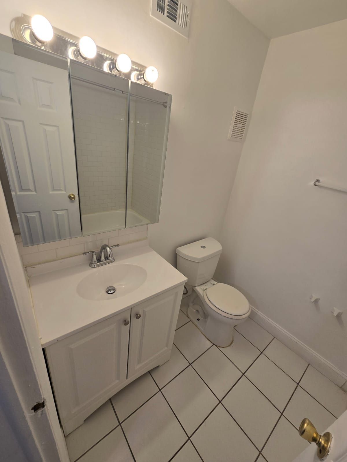 Bathroom vanity with mirror and bright lighting at Chateau Apartments Burlington, NJ