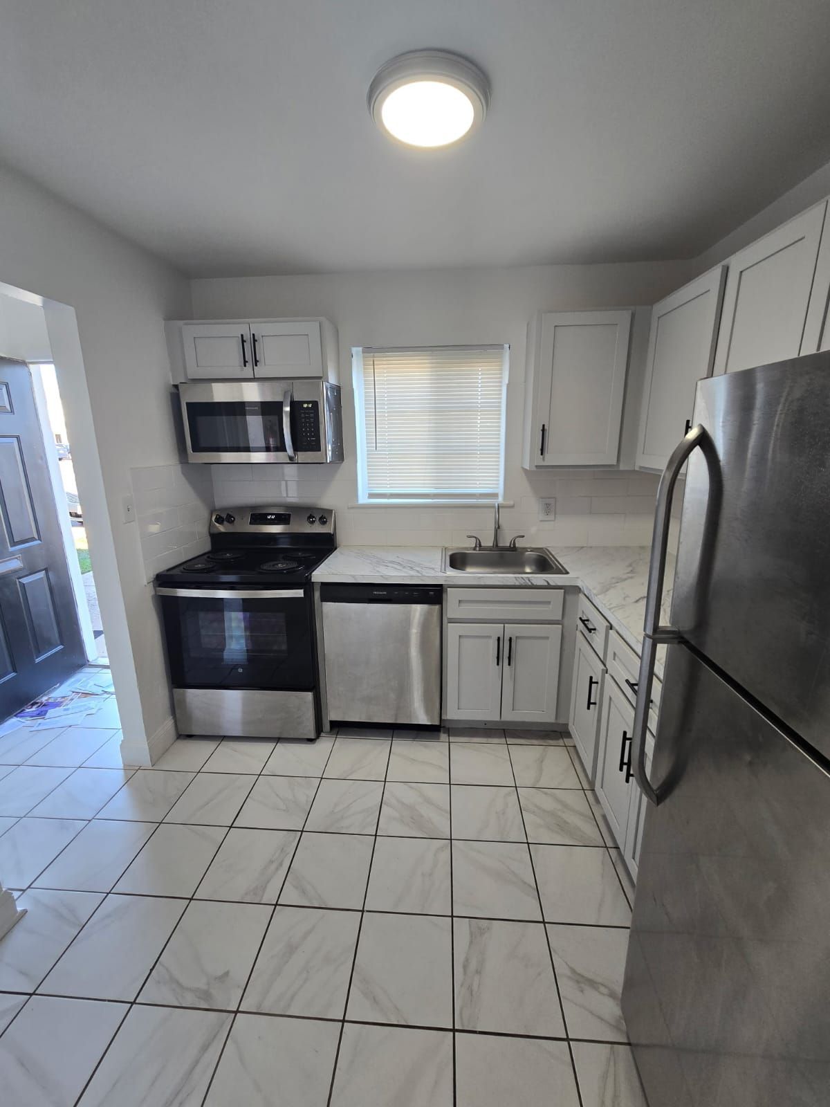 Kitchen with white cabinets, stainless steel appliances, and overhead lighting at Chateau Apartments Burlington, NJ