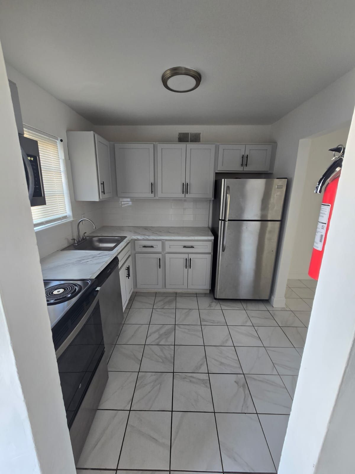 Modern white kitchen with cabinets and overhead lighting at Chateau Apartments Burlington, NJ