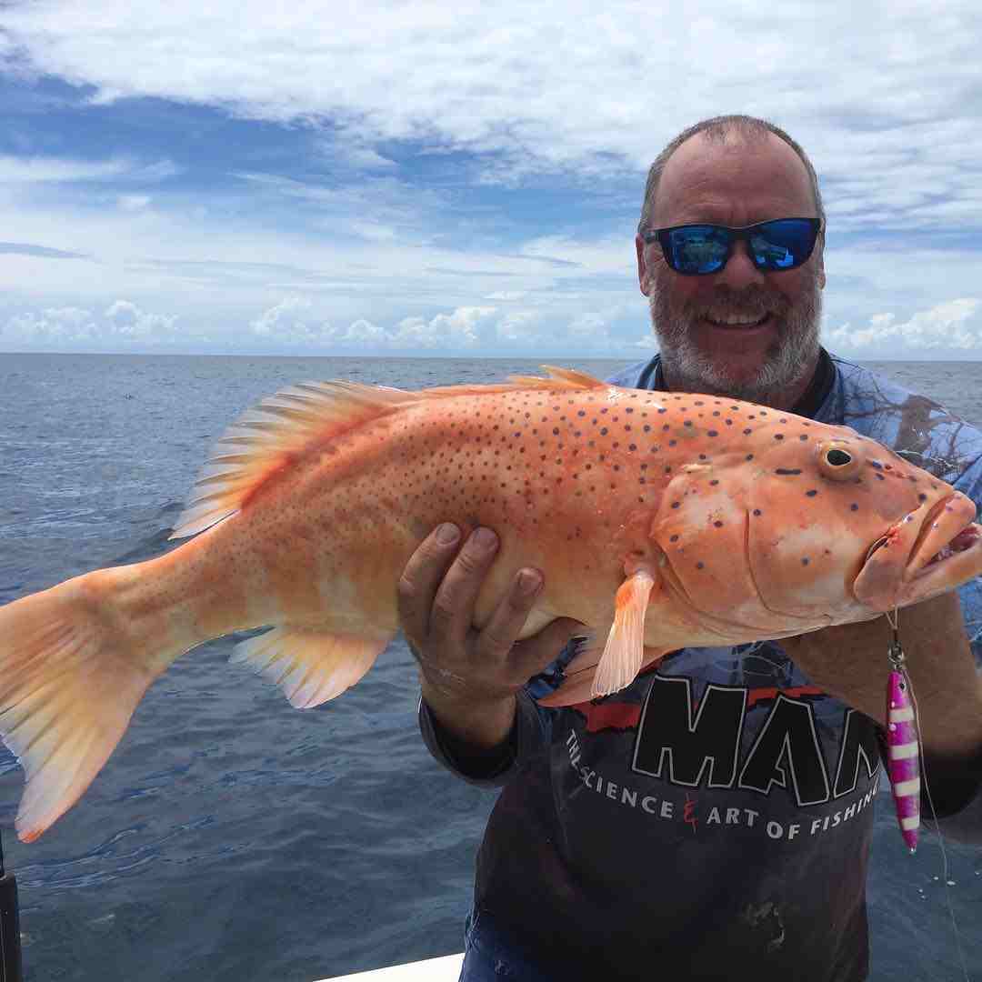 一名男子拿着一条橙色的鱼——渔服Yeppoon，昆士兰州Y开云体育app官网下载安装eppoon