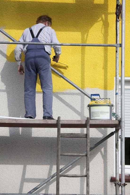 pittura di una parete esterna con vernice gialla