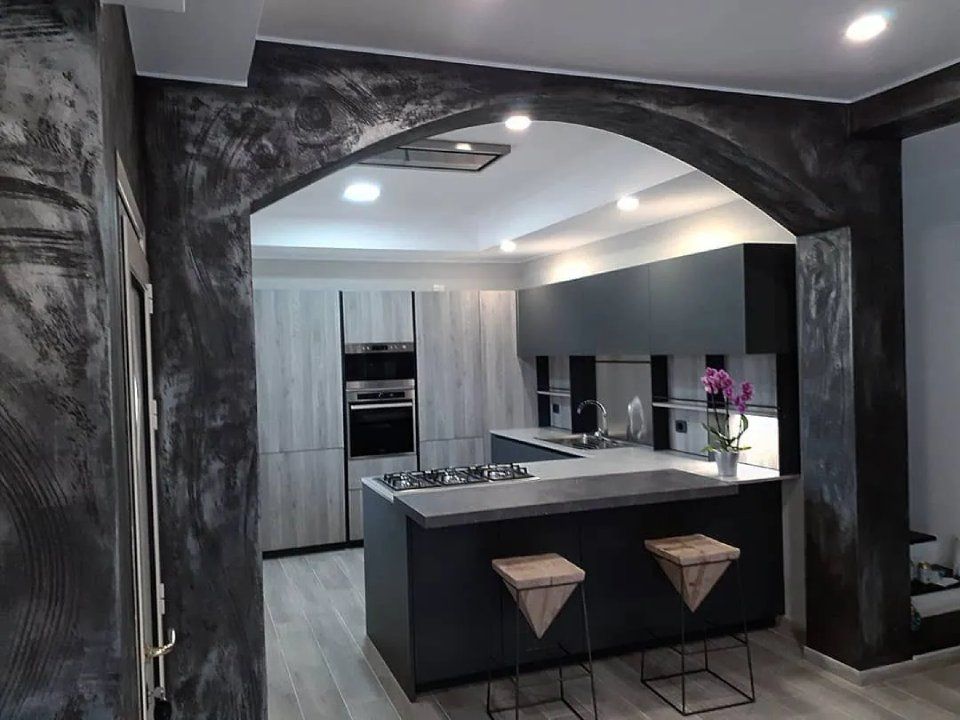 cucina con penisola e arco in cartongesso grigio metallizzato