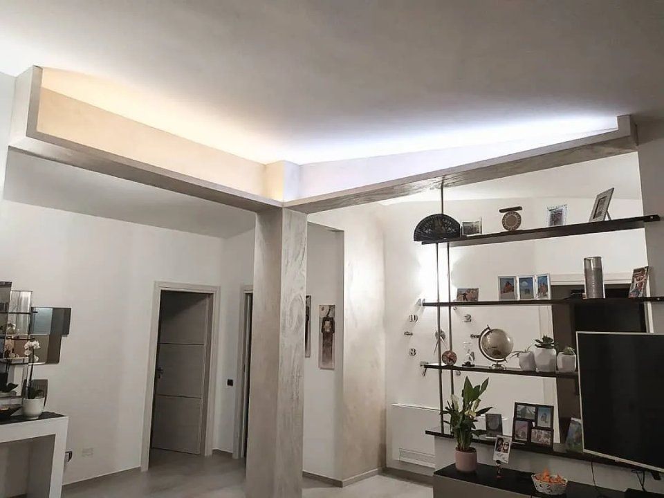 salotto con colonna e controsoffitto color grigio chiaro