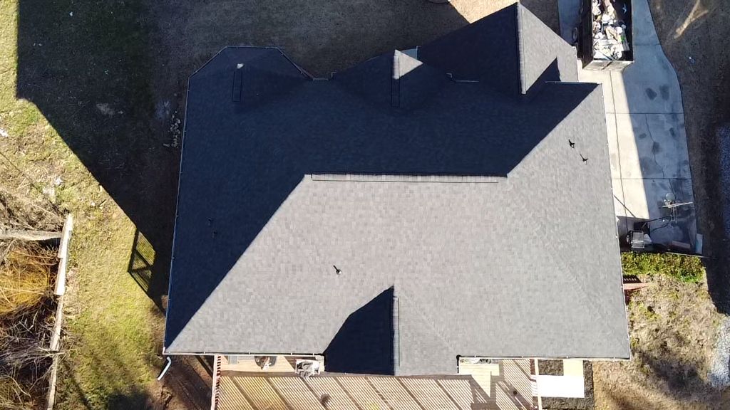 An aerial view of a house with a black roof