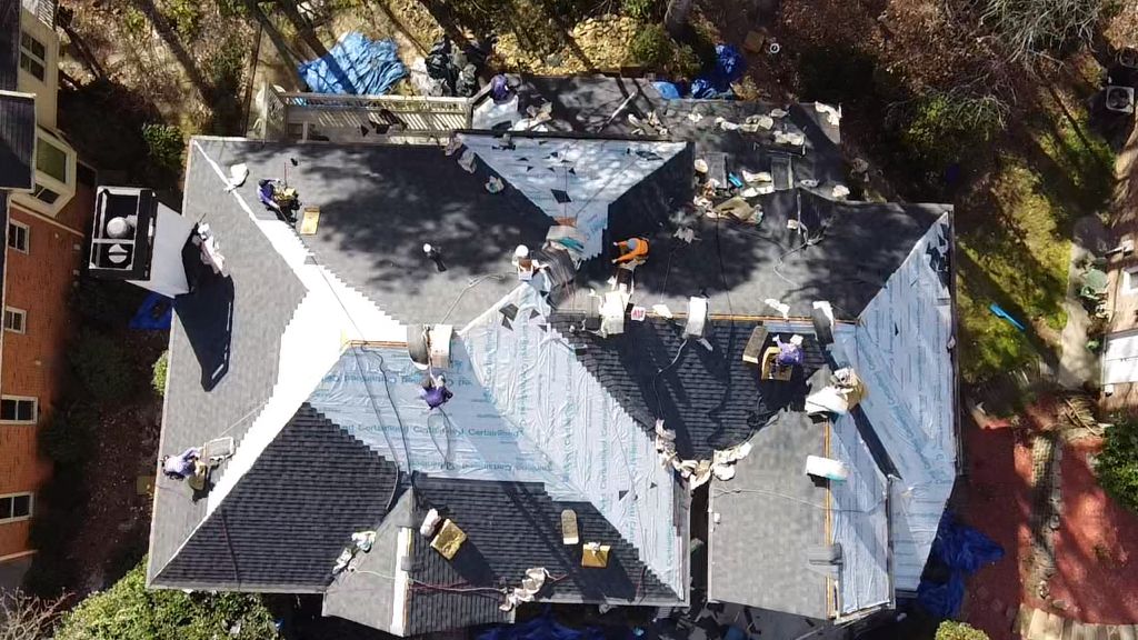 An aerial view of a house with a roof being repaired.