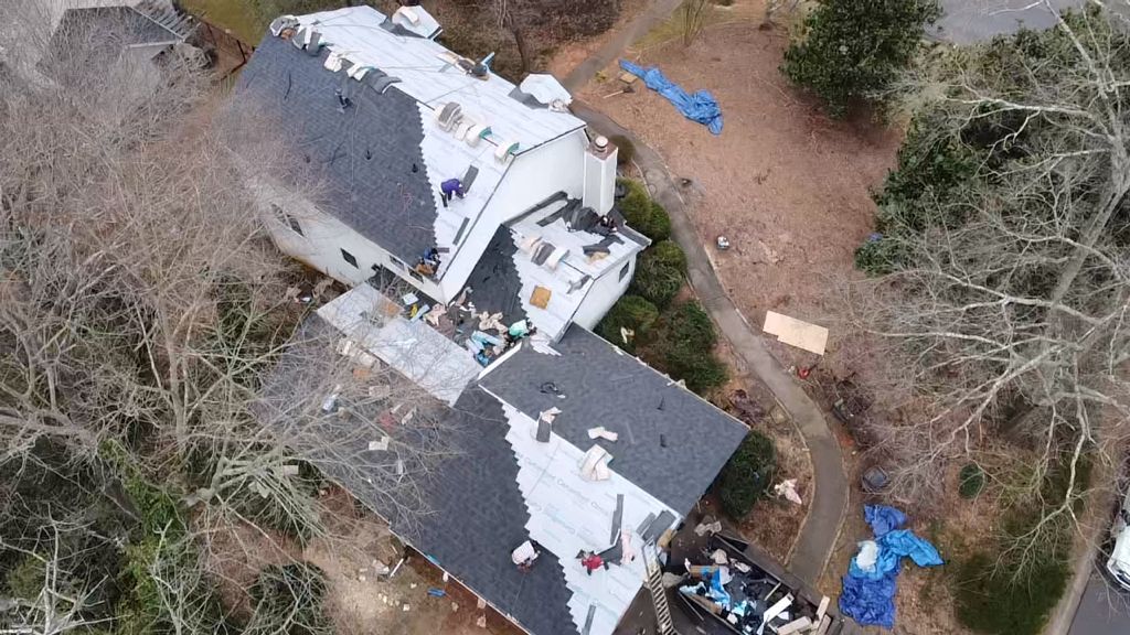 An aerial view of a house with a roof that is being repaired.